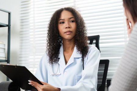 Doctor listens attentively to patient concerns in consultationの写真素材