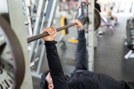 Strength Training. Man lifting weights on a bench press in the gym.