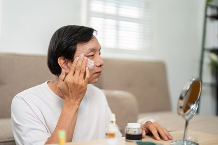Elderly Self-Care. A senior man applying skincare products at home.の写真素材