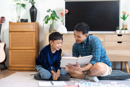 Father and son reading together during quality family timeの写真素材
