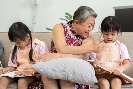 Learning and Bonding. A grandmother engages with her granddaughters as they work on their school...