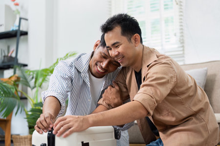 Travel Planning and Couple Bonding. A loving couple prepares for their upcoming trip, sharing joy and excitement in a cozy home setting.の写真素材
