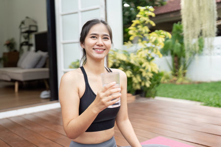Healthy Lifestyle and Hydration. Young woman enjoying a drink of water after her fitness routine...
