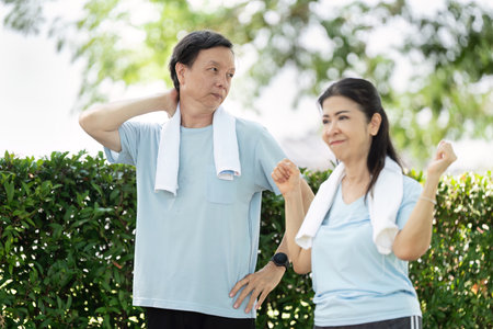 Wellness and Senior Stretching. A senior couple enjoying a light workout and stretching routine in a park.の写真素材