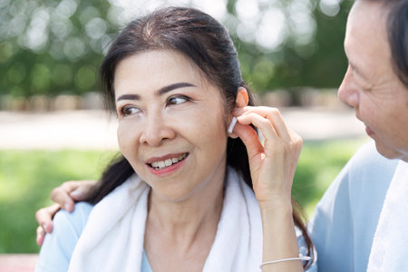 A senior couple enjoying music together while exercising outdoors.の写真素材