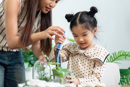 Gardening Together. A mother helps her daughter with indoor plant care.の写真素材