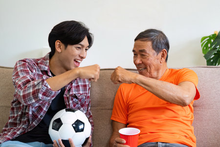 Celebrating Together. Grandfather and grandson sharing a fist bump after a game.の写真素材