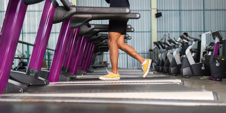 Close-up of legs exercising on treadmill in fitness center