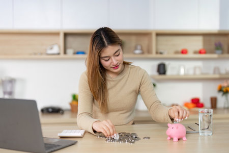 Financial Planning. Young Woman Depositing Coins into Piggy Bankの写真素材