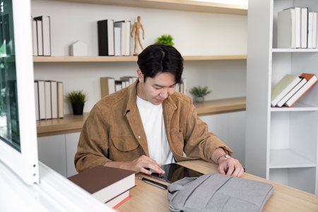 Remote Work and Collaboration. Young man using tablet at modern workspace.の写真素材