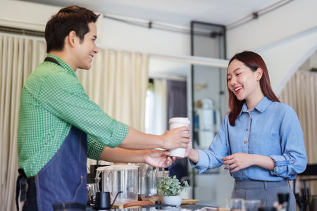 Sustainability and Customer Experience. A barista serving a coffee to a happy customer.の写真素材