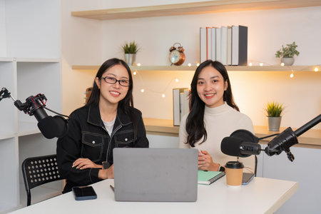 Podcast Hosts Smiling and Collaborating in Modern Studioの写真素材