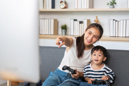 Family Gaming Fun. Mother and child playing video games together.の写真素材