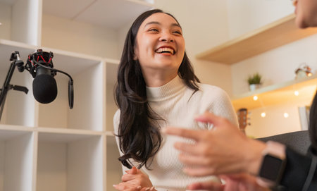 Podcast recording session with joyful women sharing laughterの写真素材