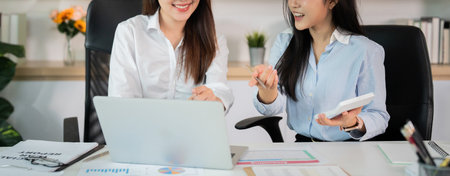 Collaboration in the Workplace. Two women discussing project details at a modern office.の写真素材