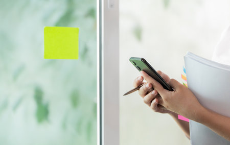 Close-up of hands holding smartphone and document in office