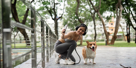 Active Lifestyle. Young Woman Exercising with Corgi in Parkの写真素材