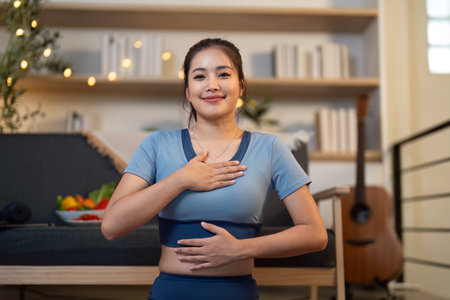 Yoga and Self-Care. Young woman practicing breathing exercises at home for emotional wellness.の写真素材