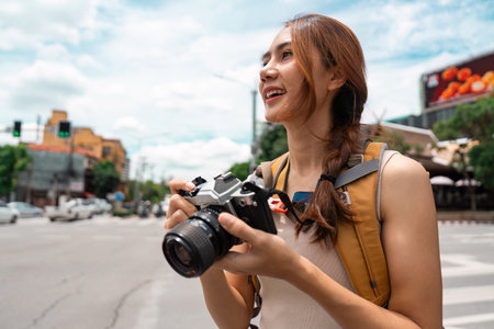 Travel Enthusiast Capturing Moments with Camera in Urban Settingの写真素材