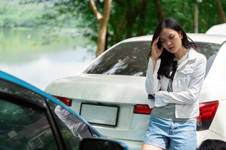 Insurance Stress. A woman looking worried after a car accident, waiting for assistance.の写真素材