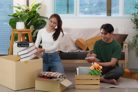 Young Adults Unpacking Boxes and Setting Up New Homeの写真素材