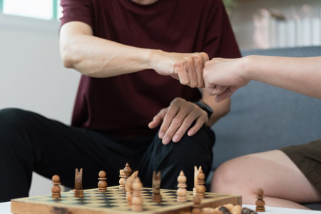 Friendly competition. Two friends fist bumping after a chess game.の写真素材