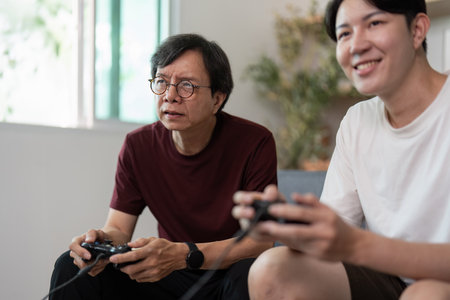 Father and Son Gaming Together. A joyful moment captured during a video game session.の写真素材