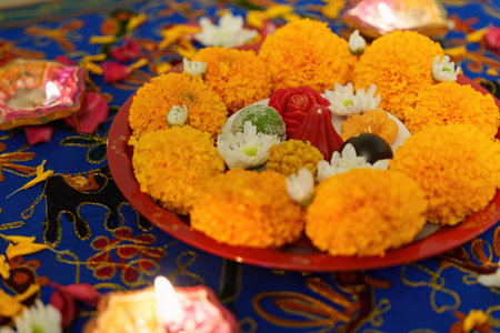 Diwali Celebration. Marigold flowers and sweets arranged beautifully on a festive table.の写真素材