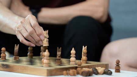 Strategic Play. Close-up of hand moving chess piece during game.の写真素材