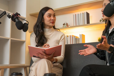 Podcast Recording. Engaging conversation between two women in a creative workspace.の写真素材