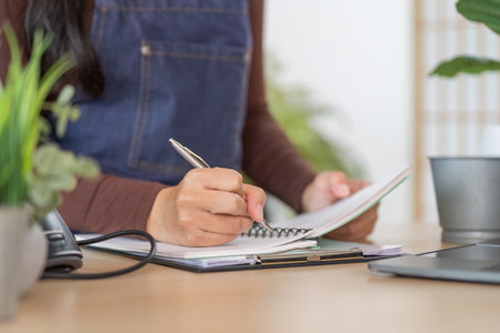 Floral Business Owner Writing in Notebook at Desk