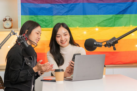 LGBTQ women enjoying a digital conversation in a colorful studioの写真素材