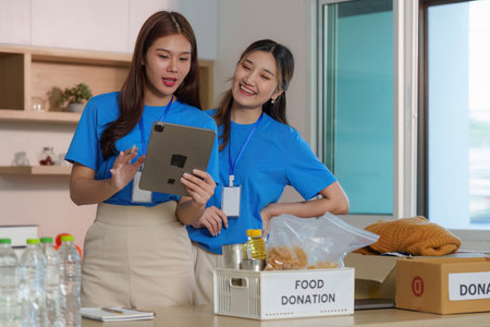 Food Donation Awareness. Volunteers discussing food donation efforts using a tablet.