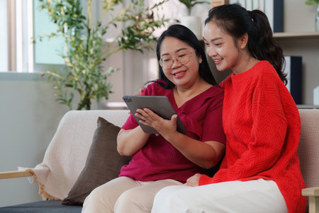 Joyful moments. Mother and daughter enjoying time together with a tablet.の写真素材