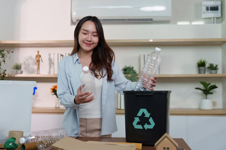 Recycling. Woman sorting plastic bottles into recycling bin, promoting eco-awareness.の写真素材