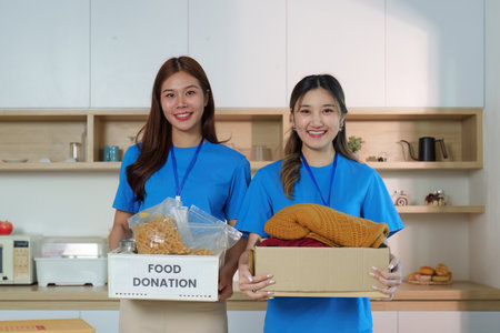 Women Holding Donation Boxes: Community Spirit and Generosityの写真素材