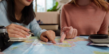 Travel Planning. Friends discussing itinerary over a world map.の写真素材