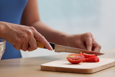 Wellness. Slicing ripe tomatoes for a nutritious salad.の写真素材