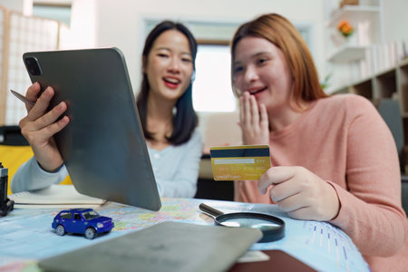 Travel Planning. Friends excitedly booking their trip online.の写真素材