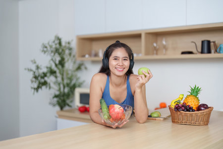 Wellness. Happy woman preparing healthy meal with fresh fruits and vegetables at home.の写真素材