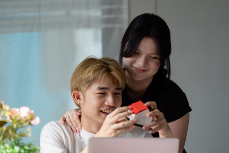 Young Couple Exploring Real Estate Options Online in a Modern Home Settingの写真素材