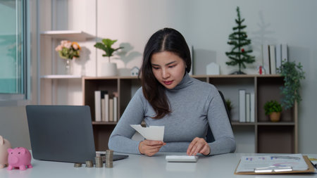 Financial Empowerment: Woman Managing Budget with Receipt and Calculatorの写真素材