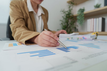 Data Analysis. Business professional analyzing financial graphs and charts on a desk.の写真素材