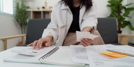Tax management. Young woman organizing financial paperwork at home.の写真素材