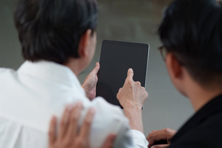 Hobby Family: Two men engaging with a tablet, sharing ideas and technology.