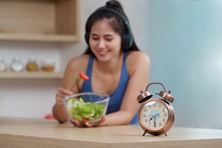 Food Wellness: Enjoying a Healthy Salad with a Timer for Mindful Eatingの写真素材