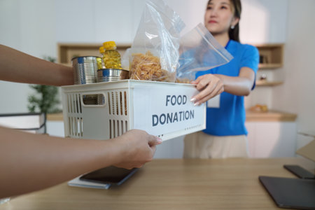Food Donation Delivery. Volunteer handing over food items to support community needs.