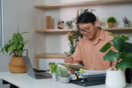 Inclusive Workspace. Young professional engaged in creative work at a modern desk.の写真素材
