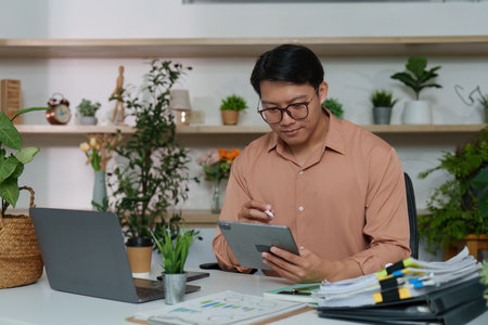 Digital Workspace. Professional using tablet for project management in office.の写真素材