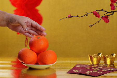 Chinese New Year with oranges and red envelope on golden backgroundの写真素材